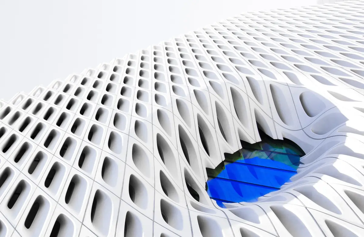 una escultura arquitectónica con una ventana azul que parece un ojo hacia el futuro